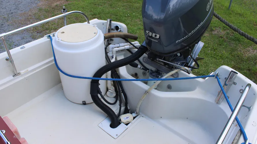 Yamaha 90hp outboard engine and live well on a 1982 Boston Whaler 17 Montauk, showcasing the boat's center console design and engine setup.