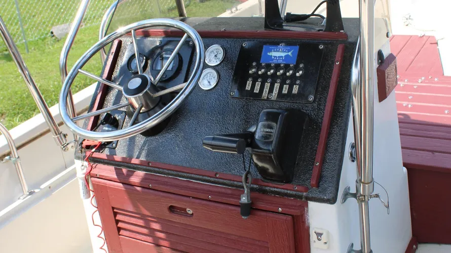 Boat dashboard of a 1982 Boston Whaler 17 Montauk featuring steering wheel, engine controls, gauges, and a Yamaha outboard motor display.