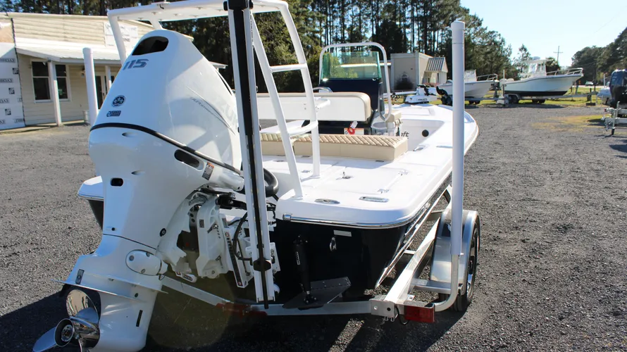 2025 Action Craft 17 Flyfisher boat with Suzuki DF115 outboard engine, showcasing sleek design and trailer in sunny marina setting, highlighting features for fishing enthusiasts.