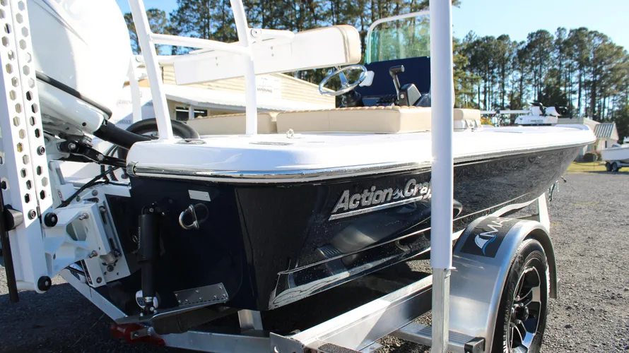 2025 Action Craft 17 Flyfisher boat showcasing sleek design, blue hull, and Suzuki outboard engine, positioned on a bunk trailer at Cape Romain Marine dealership.