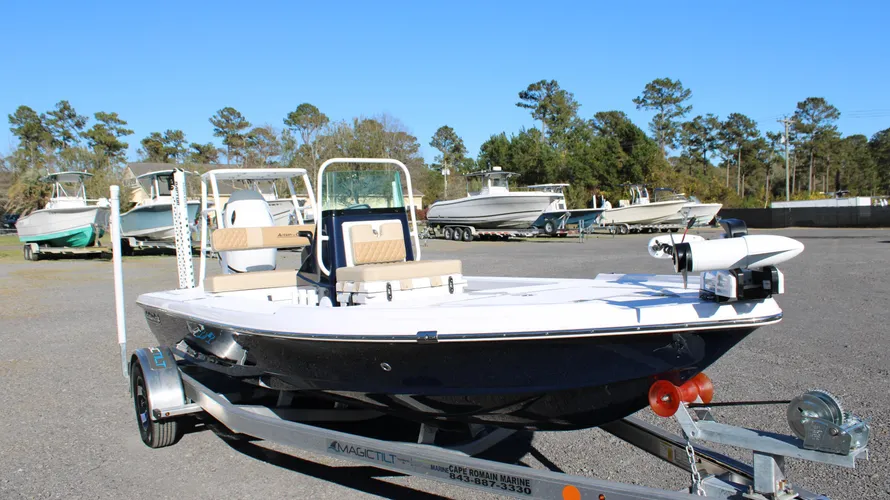 2025 Action Craft 17 Flyfisher boat on trailer, featuring a sleek black hull and beige seating, displayed at Cape Romain Marine with other boats in the background, emphasizing its excellent condition and suitability for fishing.
