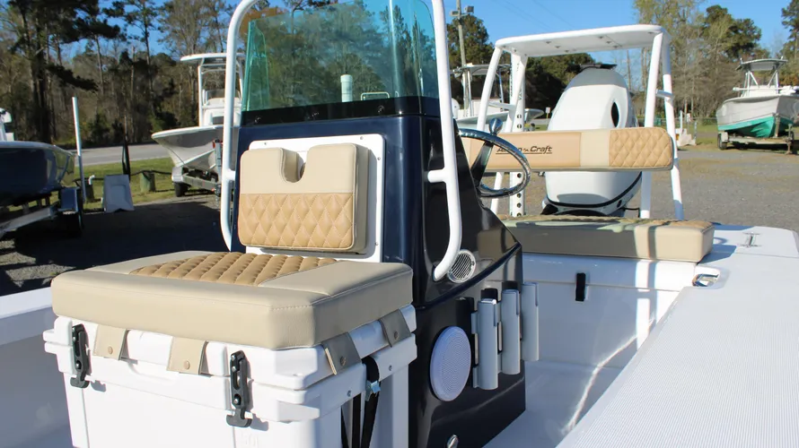 Interior view of the 2025 Action Craft 17 Flyfisher showcasing beige seating, steering console, and outboard motor, highlighting its design and features for potential buyers at Cape Romain Marine.