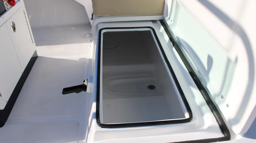Storage compartment on 2025 Action Craft 17 Flyfisher boat, featuring a sleek black lid and integrated handle, highlighting the boat's functionality and design.