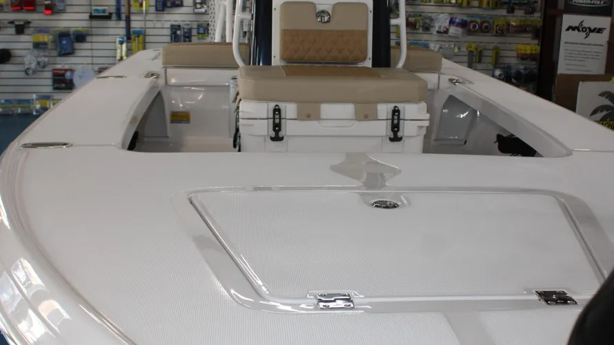 Interior view of the 2025 Action Craft 17 Flyfisher boat, featuring a spacious white deck, cushioned seating, and storage compartments, showcasing its design and functionality for fishing enthusiasts.