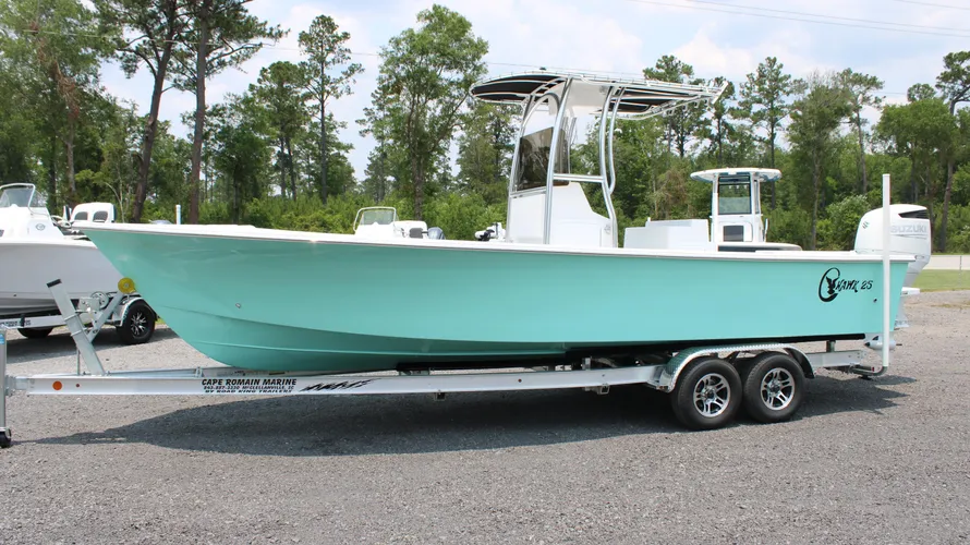 2025 C-Hawk 25 Center Console boat in mint green color on a trailer, showcasing its sleek design and Suzuki outboard motor, set against a natural backdrop, highlighting its suitability for saltwater fishing.