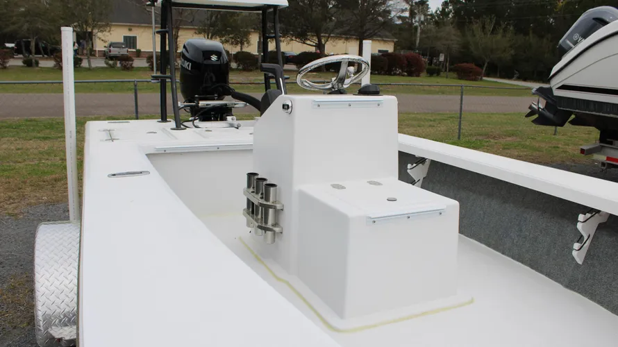 Interior view of the 2025 17 Tournament Mitzi Skiff showcasing the helm, seating, and Suzuki outboard motor, highlighting features for fishing and recreational use.