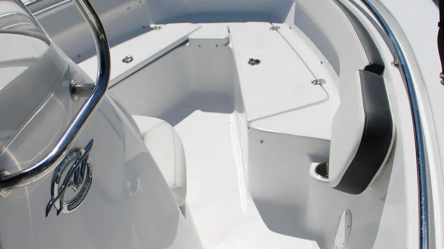 Interior view of the 2025 Tidewater Boats 198CC showcasing sleek white fiberglass seating, a polished stainless steel railing, and ample storage compartments, emphasizing its modern design and functionality for marine adventures.