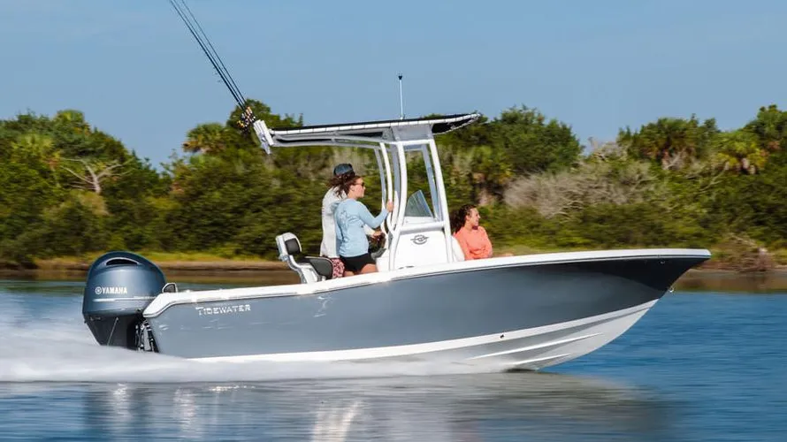 2025 Tidewater Boats 198CC in action on water, featuring Yamaha outboard engine, two passengers enjoying a ride, and lush greenery in the background.