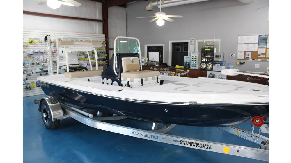 2025 Action Craft 17 Flyfisher boat displayed at Cape Romain Marine, featuring a blue hull, outboard engine, and interior seating, with a retail environment in the background.