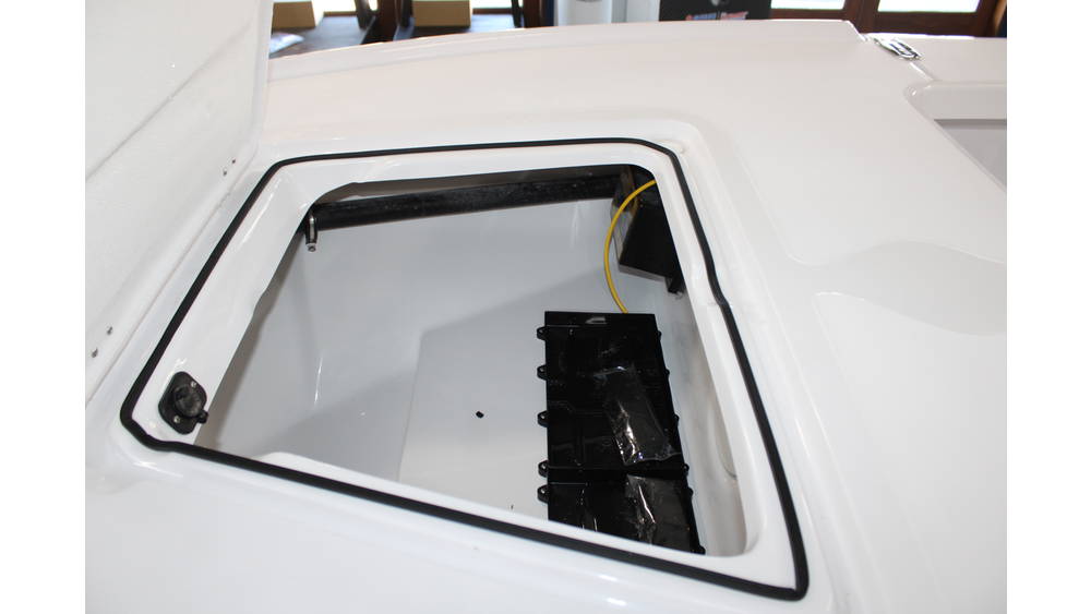 Storage compartment of the 2025 Action Craft 17 Flyfisher boat, featuring a white interior and visible electrical wiring, highlighting its marine design and functionality.