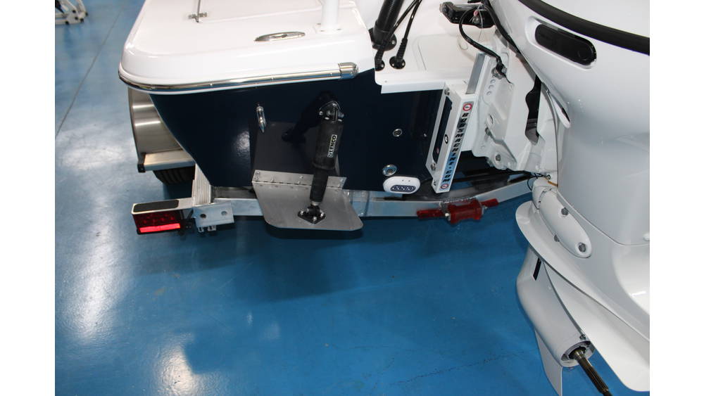 2025 Action Craft 17 Flyfisher rear view showcasing Suzuki outboard motor, boat features, and sleek blue hull on showroom floor.
