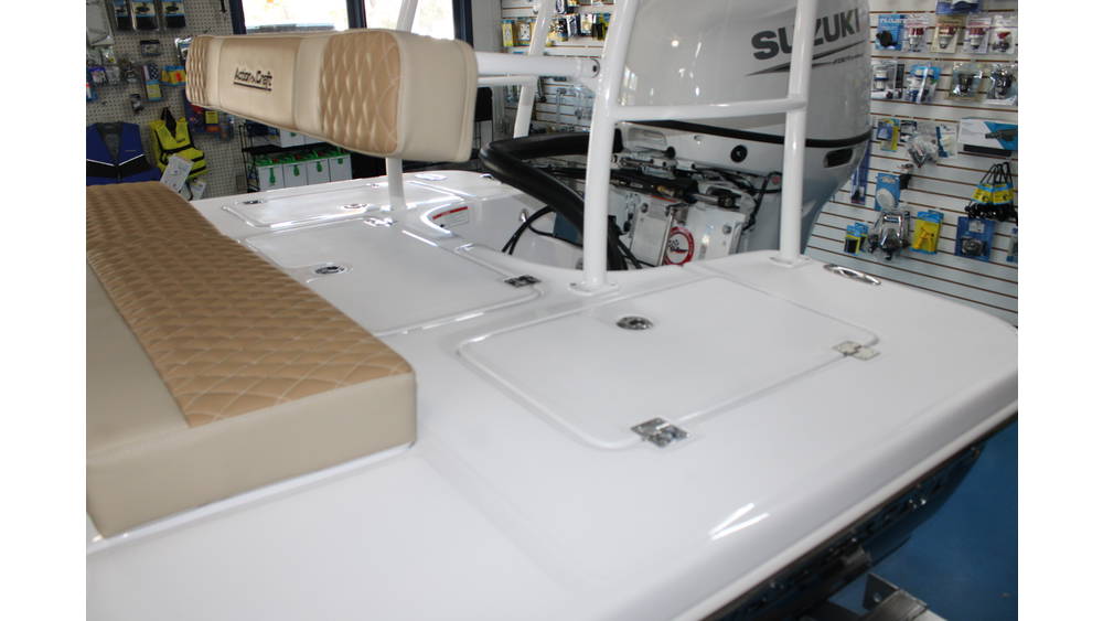 Action Craft 17 Flyfisher boat interior featuring a padded seating area and Suzuki outboard motor, showcasing quality craftsmanship and marine accessories in the background.
