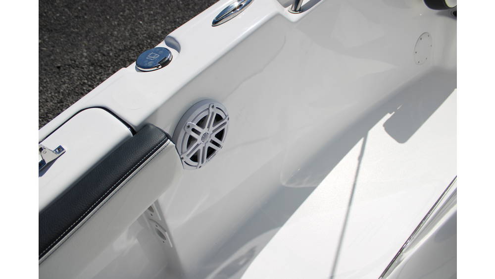 Detail of the interior of a 2025 Tidewater Boats 198CC, featuring a white fiberglass surface, a mounted speaker, and a sleek design with chrome accents.