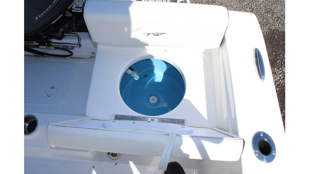 Top-down view of a 2025 Tidewater Boats 198CC, featuring a circular livewell with a blue interior, white seating, and stainless steel fittings, highlighting its fishing capabilities.