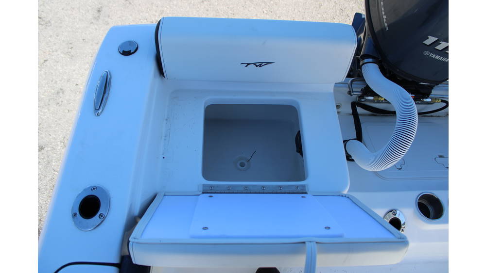 Top view of a 2025 Tidewater Boats 198CC console featuring a storage compartment, Yamaha outboard motor, and sleek white design, showcasing marine functionality and craftsmanship.