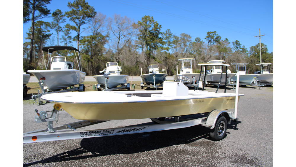 2025 17 Tournament Mitzi Skiff in Fighting Lady Yellow, showcased on a trailer at Cape Romain Marine, featuring a sleek design and surrounded by various boats in the background.