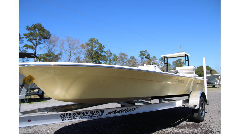 2025 17 Tournament Mitzi Skiff in Fighting Lady Yellow on a trailer at Cape Romain Marine, showcasing its sleek design and excellent condition, with trees and blue sky in the background.