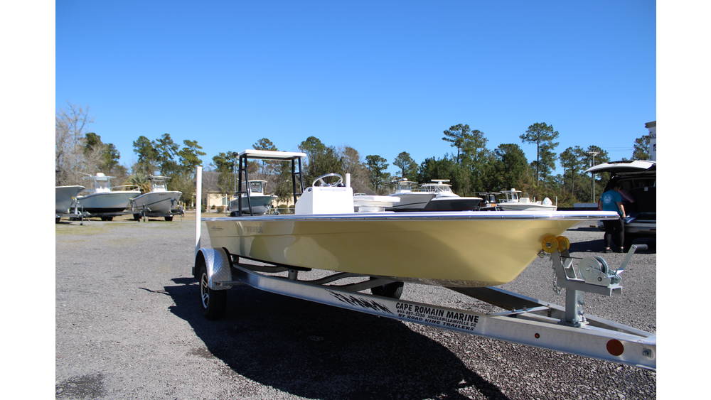 2025 17 Tournament Mitzi Skiff in Fighting Lady Yellow on trailer at Cape Romain Marine, showcasing sleek design and surrounding boats in background.