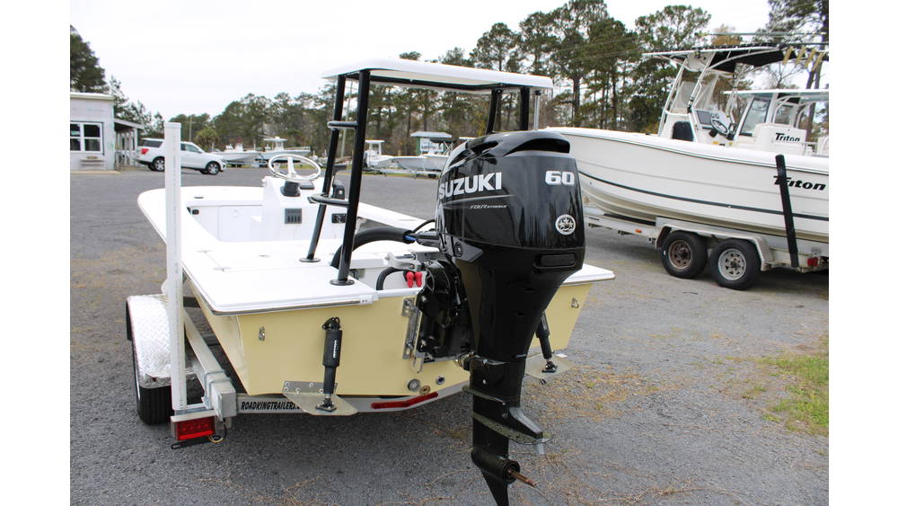 2025 17 Tournament Mitzi Skiff in Fighting Lady Yellow with a Suzuki 60hp outboard motor, showcasing a sleek design and features like a spacious deck, parked at Cape Romain Marine.