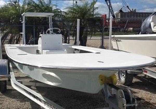 Mitzi 17 Tournament boat with baitwell console and rear release well, showcasing a sleek design and built-in fuel tank, in a marina setting.